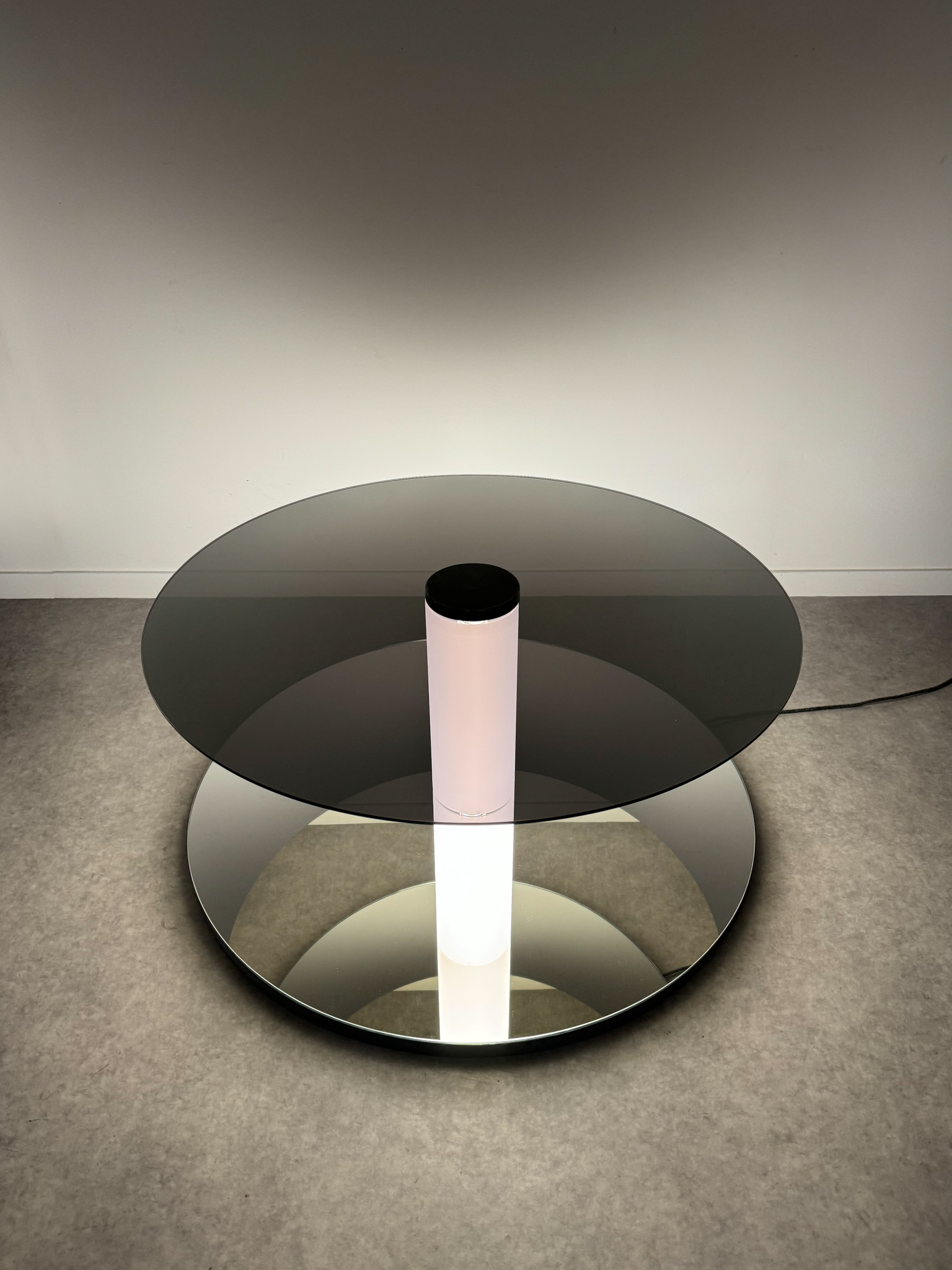 Minimalist space-time sculpture made of glass and light, creating an infinite space effect towards the ground.