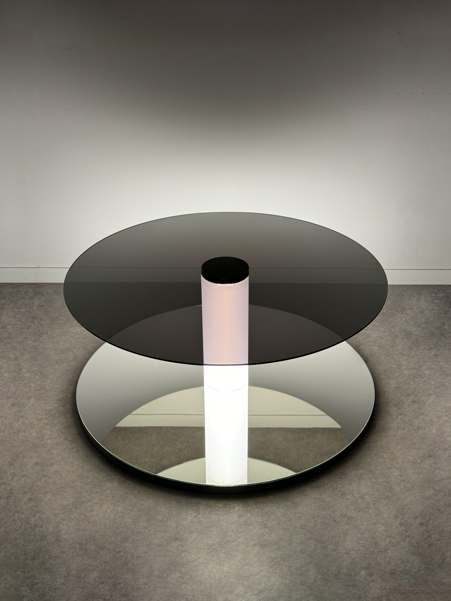 Minimalist floor sculpture "Graduate Flatfoot" made of glass, steel, and a luminous tube creating an infinite perspective.