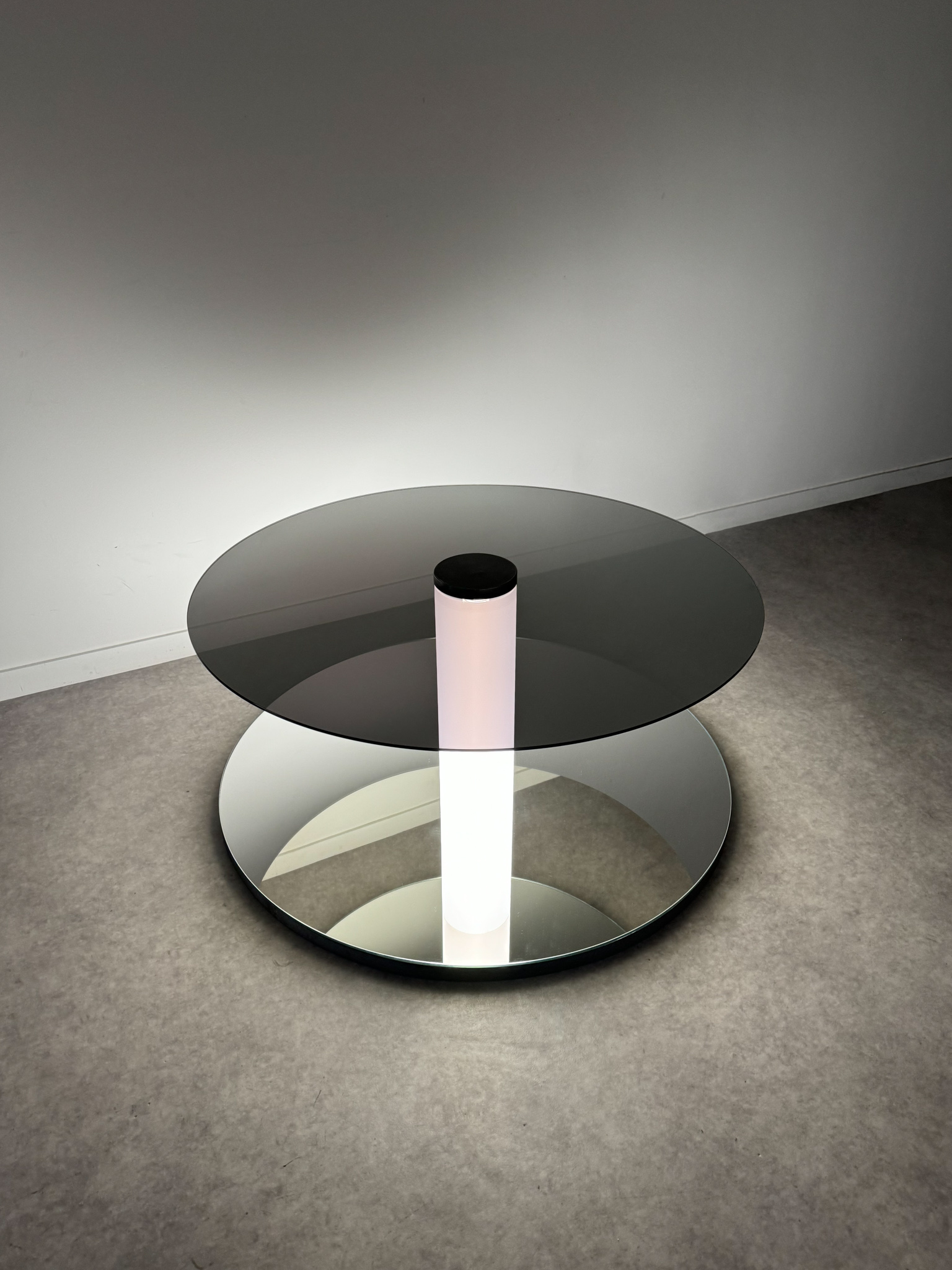 Minimalist space-time floor sculpture made of glass, steel, and a luminous tube creating an infinite perspective.