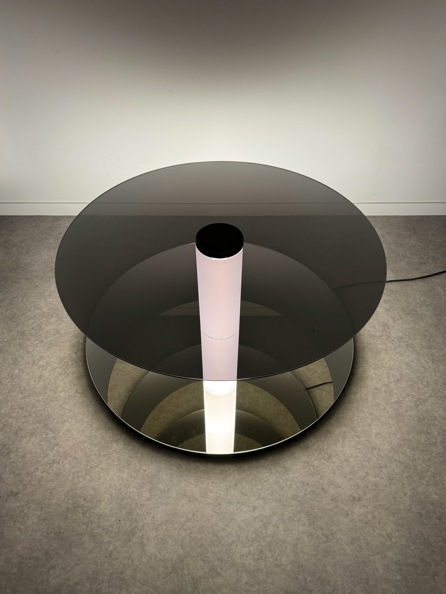 Minimalist floor sculpture "Graduate Flatfoot" made of glass and light, creating an infinite space effect towards the ground.