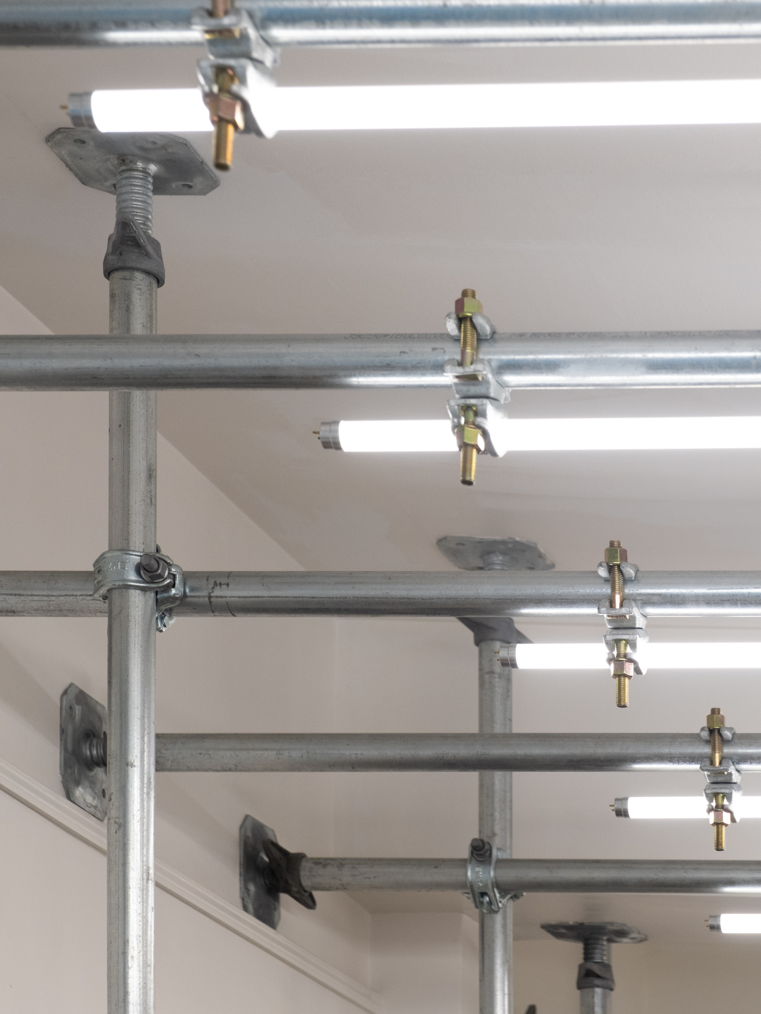 Close-up of galvanized steel scaffolding with mounted neon led lights, showcasing an industrial aesthetic blending function and minimalism.