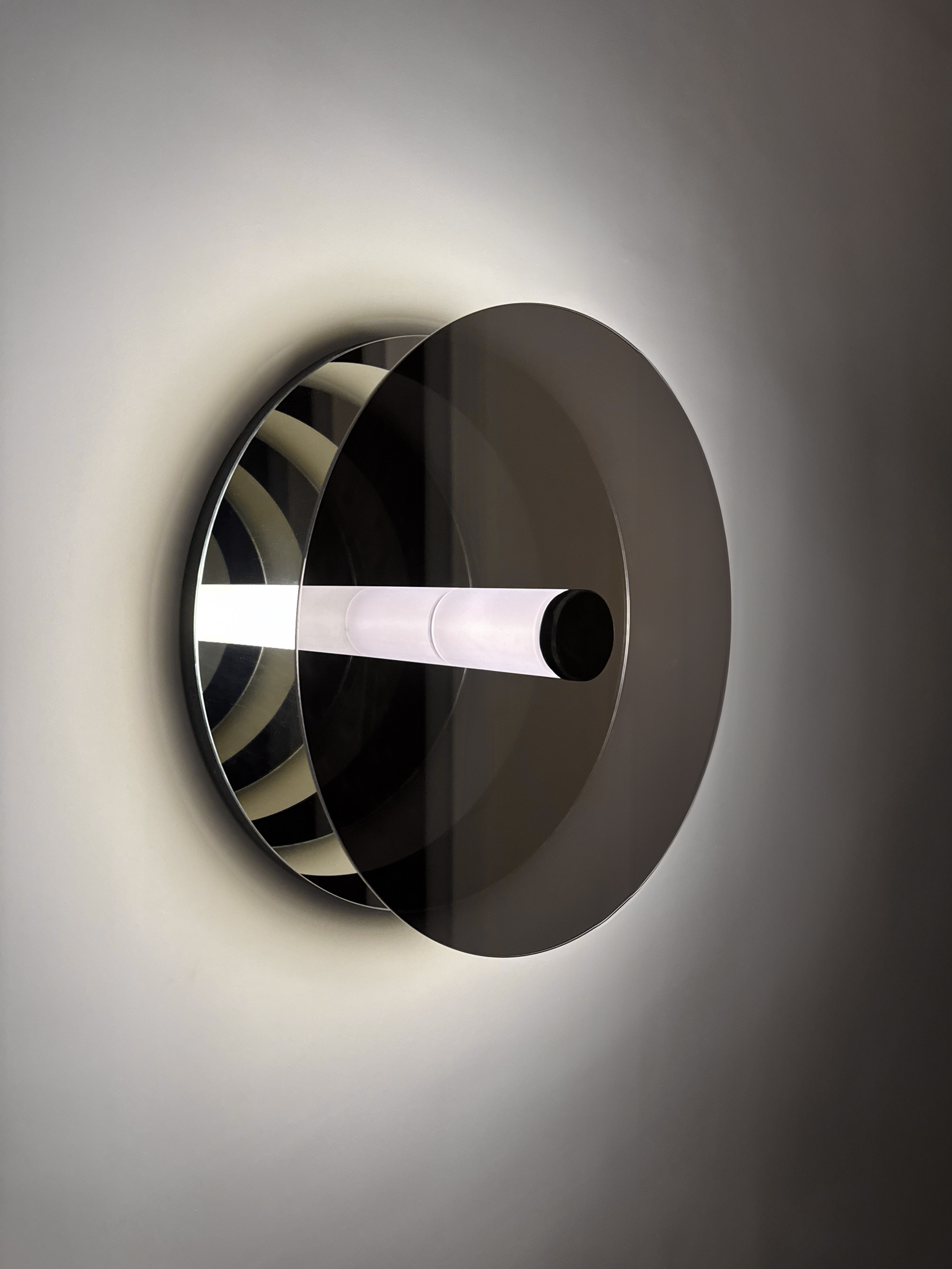 Wall sculpture titled 'Paramount Ragtime' with a glowing central tube and mirrored surfaces, creating infinite reflections and a dynamic play of light and space.