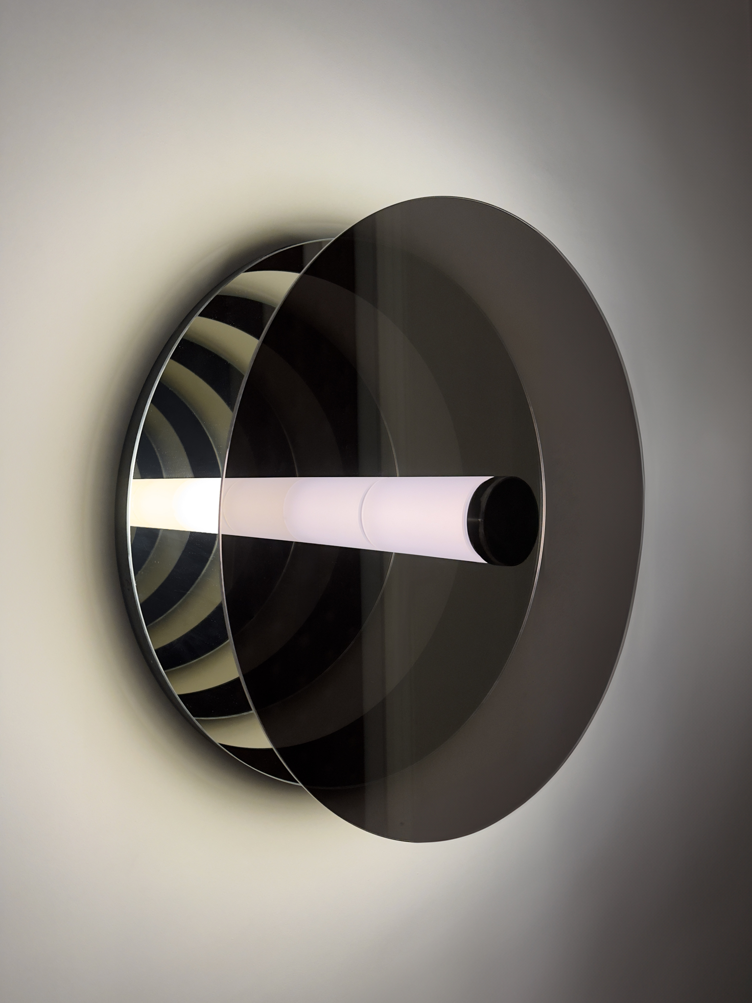 'Paramount Ragtime', a wall sculpture with a glowing central tube and mirrored surfaces, creating infinite reflections and a dynamic play of light and space.
